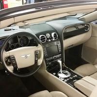 Full front dashboard, steering wheel, and audio display inside Bentley GT Continental